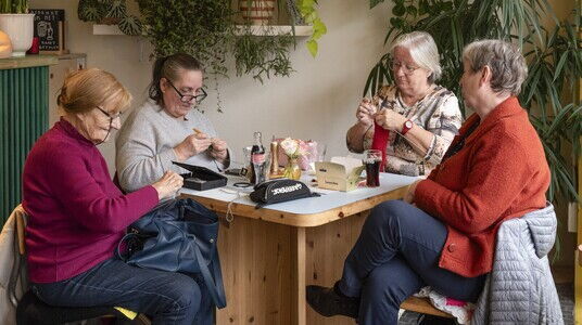 Een groep dames op leeftijd doen aan handwerk